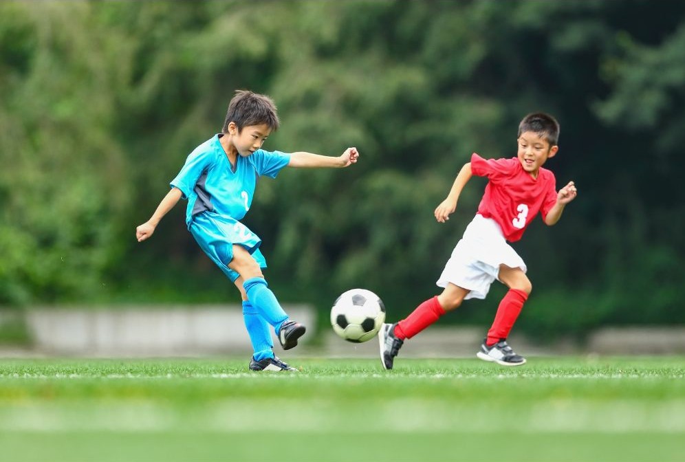 サッカーボールを蹴る子供